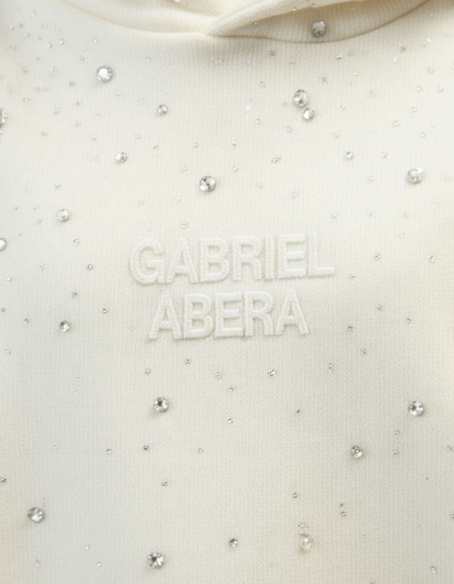 Nahaufnahme des GABRIEL ABERA Rhinestone Hoodie in Cream White – handgesetzte Rhinestones, hochwertige Stoffstruktur und Premium Verarbeitung.