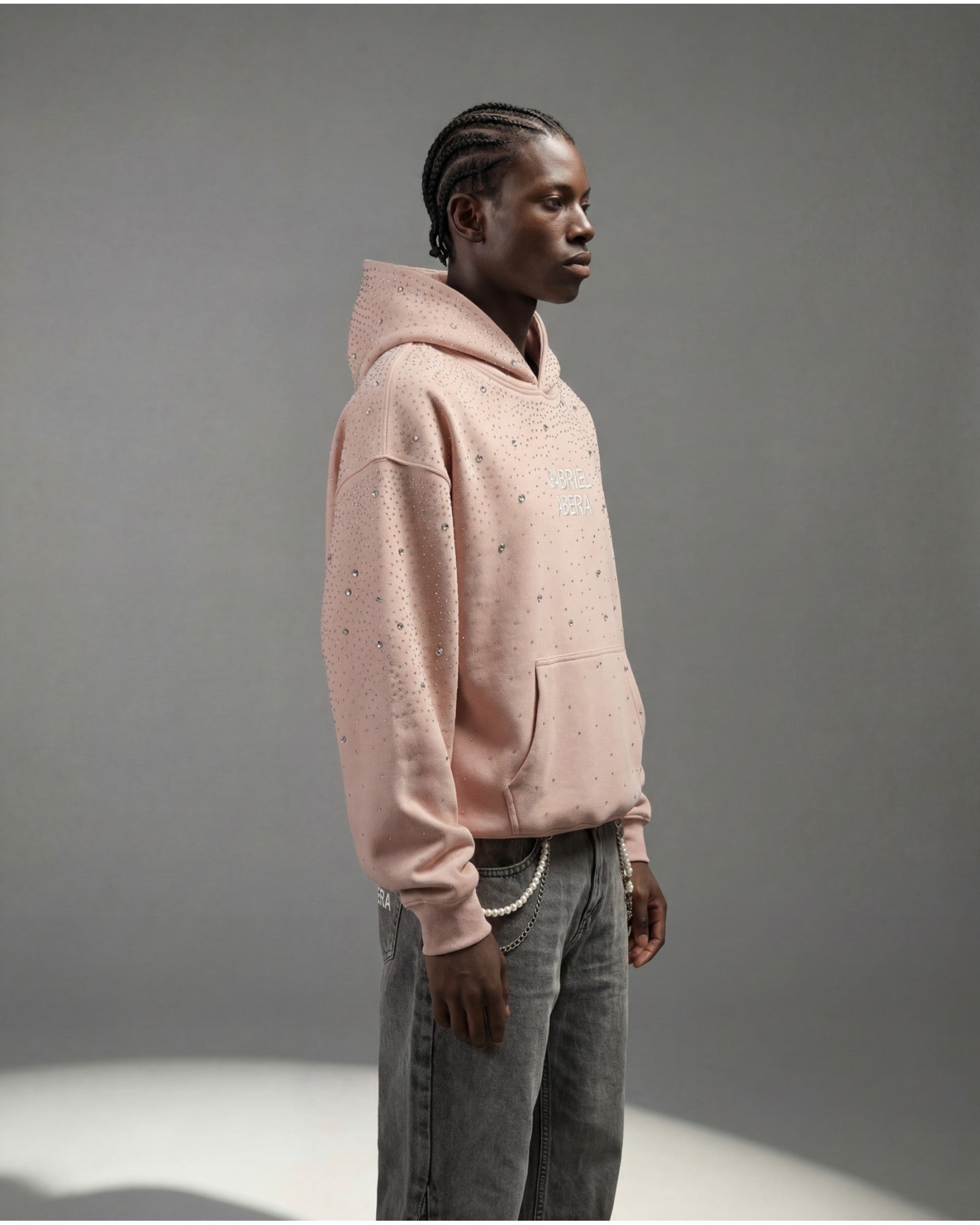 Male model side view rosa rhinestone hoodie by GABRIEL ABERA showing oversized silhouette and crystal details premium streetwear