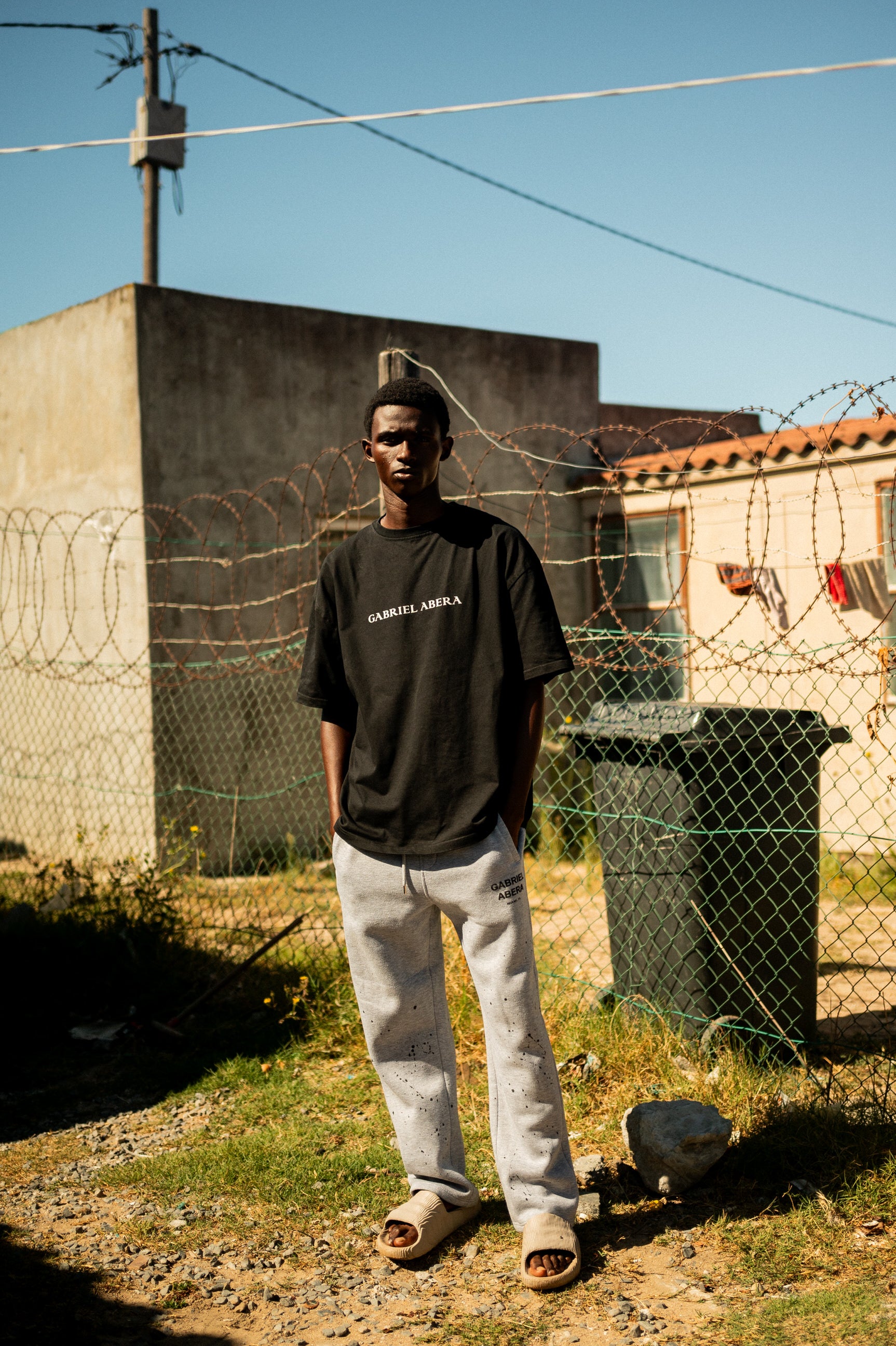Streetwear Look von GABRIEL ABERA: Sweatpants und Oversized Tee kombiniert in den Straßen von Lwandle in Kapstadt.
