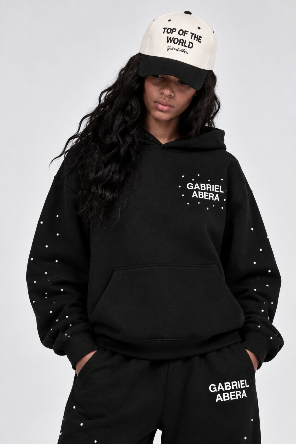 Weibliches Model trägt die cream-schwarze GABRIEL ABERA Top Of The World Snapback als modernes Streetwear Accessoire