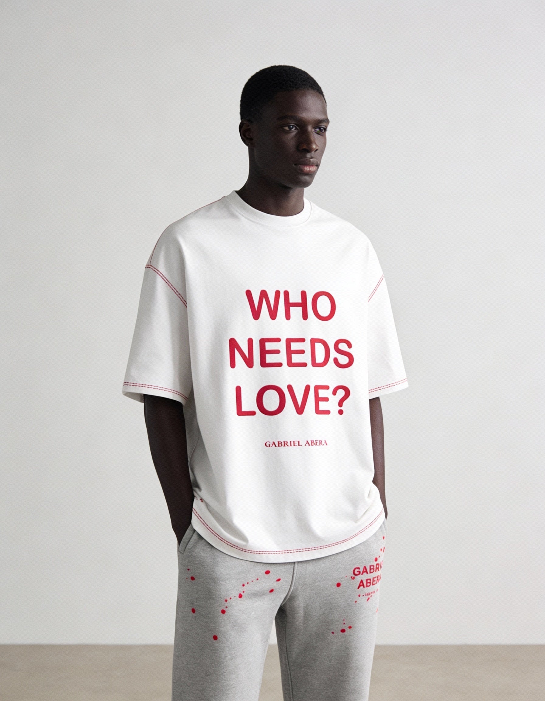 Weißes GABRIEL ABERA WHO NEEDS LOVE T-Shirt auf männlichem Model, Frontansicht mit Statement Print und modernem Streetwear Fit
