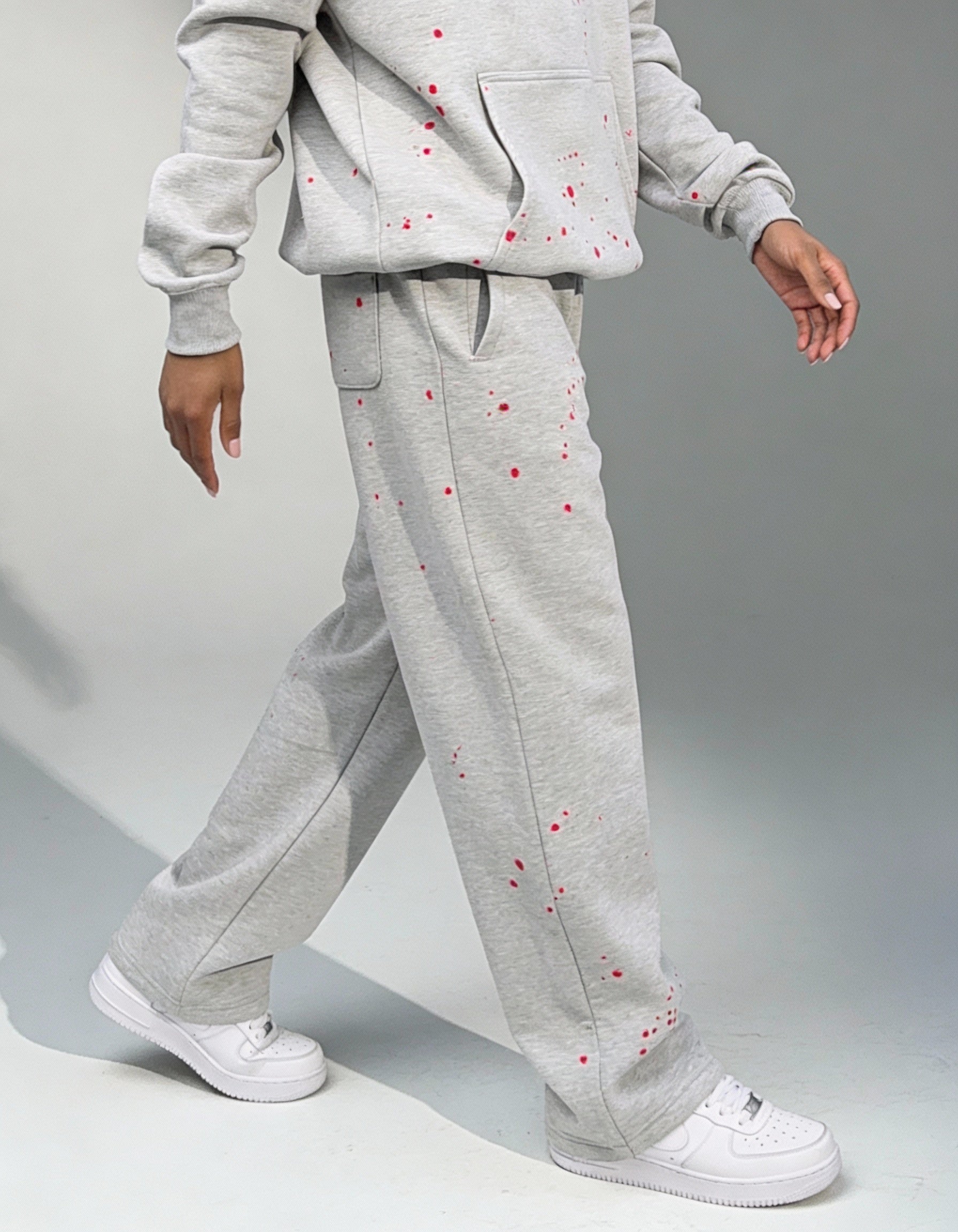 Weibliches Model seitlich fotografiert in der GABRIEL ABERA Splattered Jogginghose mit roten Paint Splatter Akzente