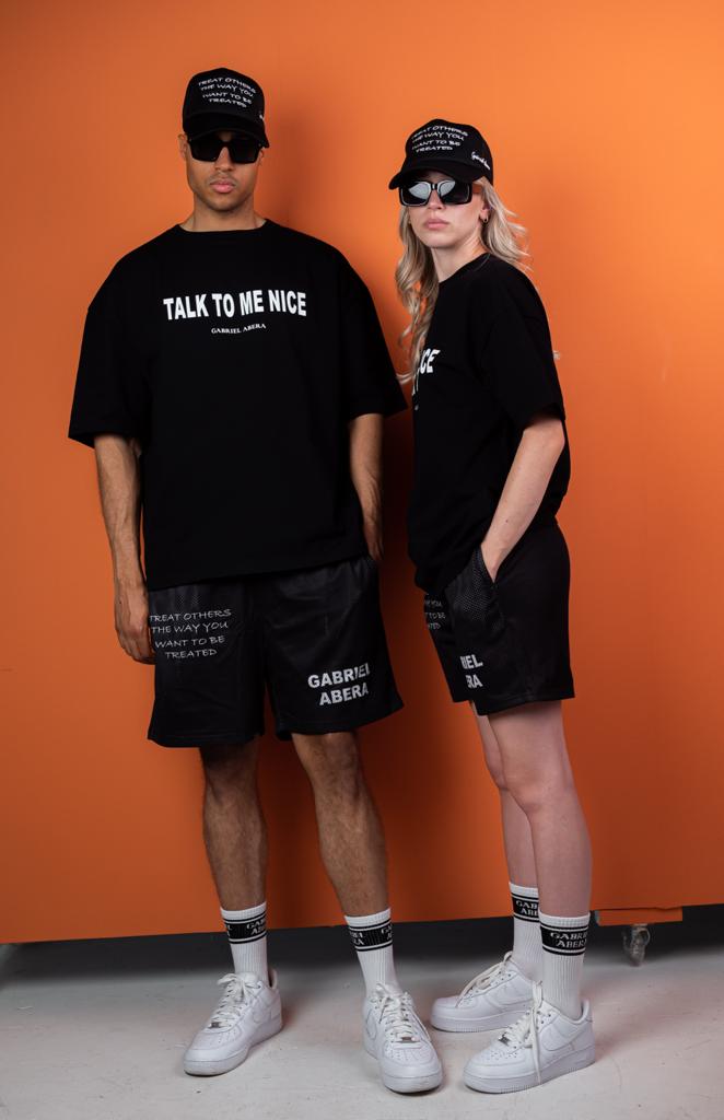 Female and Male model wearing Black mesh shorts with statement print and brandname on the front