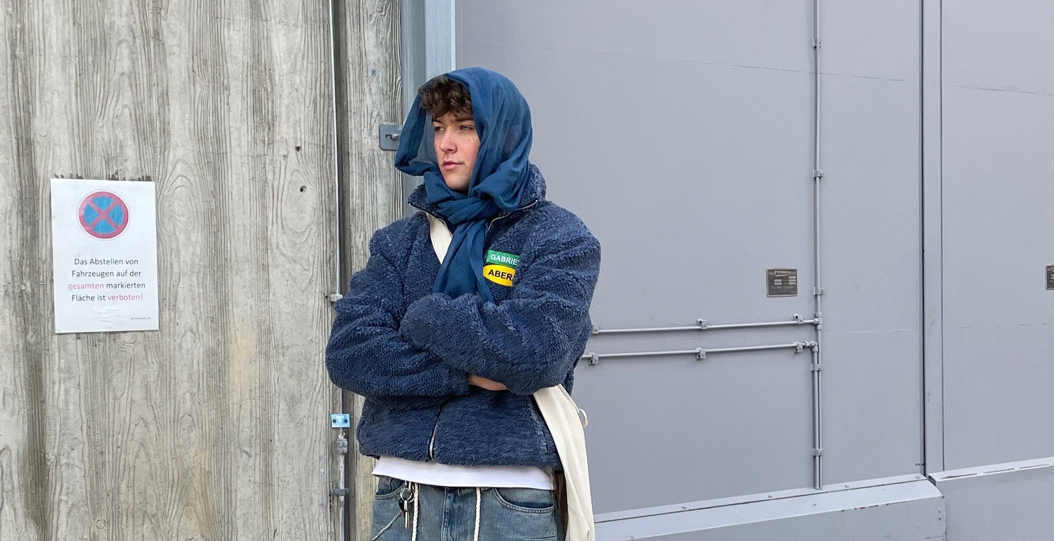 Male model wearing a Blue fleece jacket with green yellow brand patches