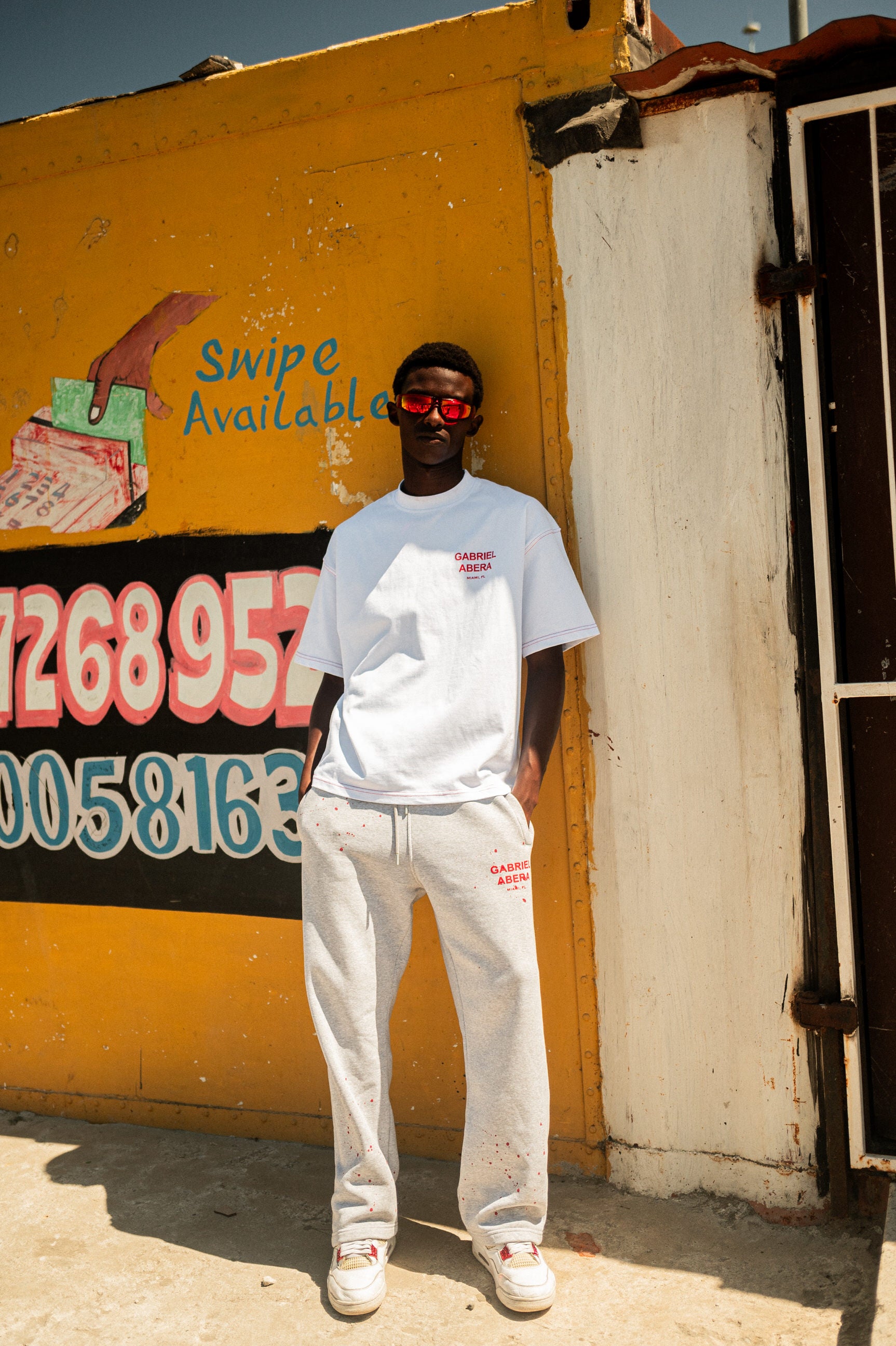 männlcihes afrikanisches Model im GABRIEL ABERA Splattered Jogginghose Design mit roten Farbspritzern