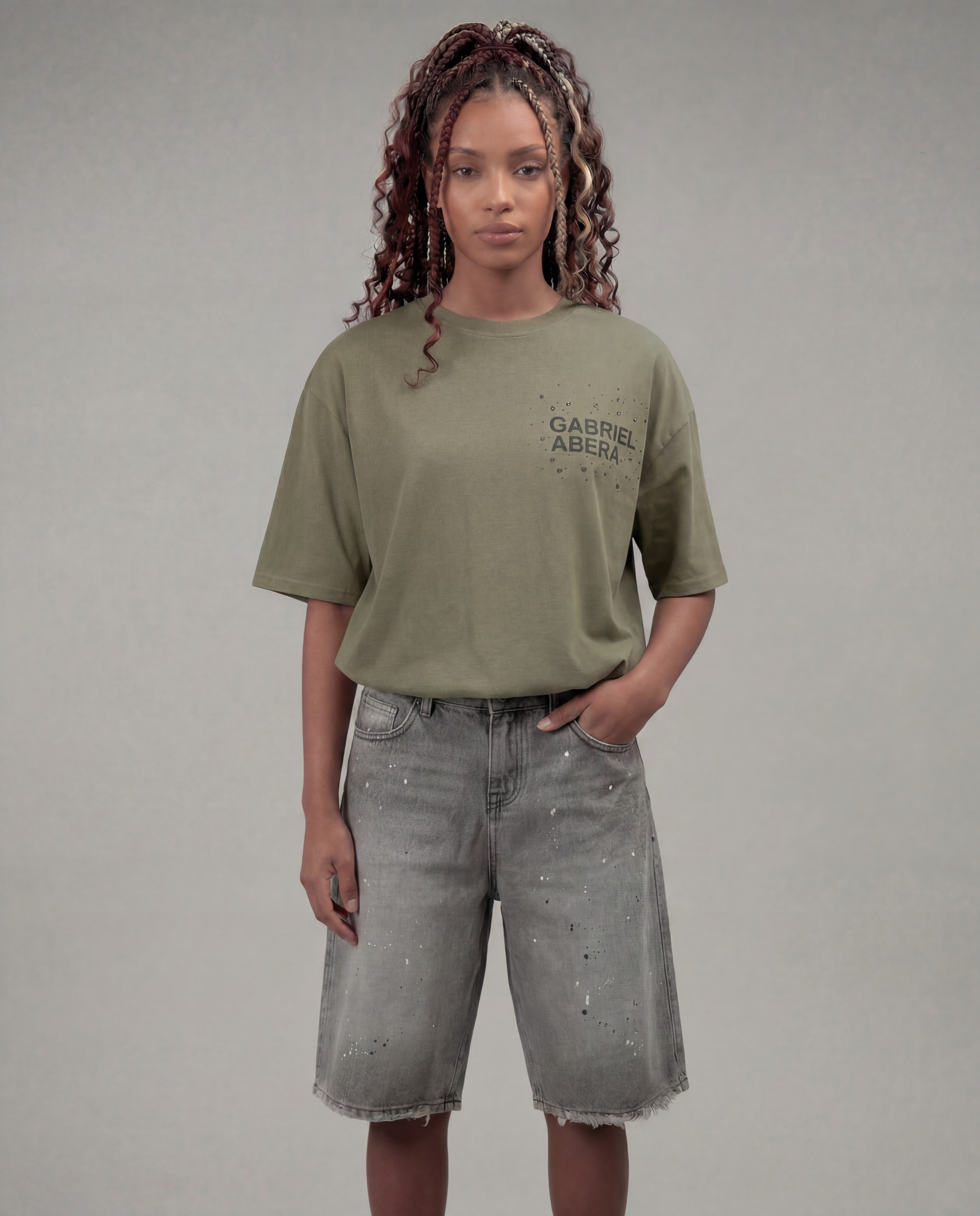 Male model wearing the Gabriel Abera Rhinestone Logo Tee in olive – back view, showcasing the oversized boxy cut and dropped shoulders, grey background
