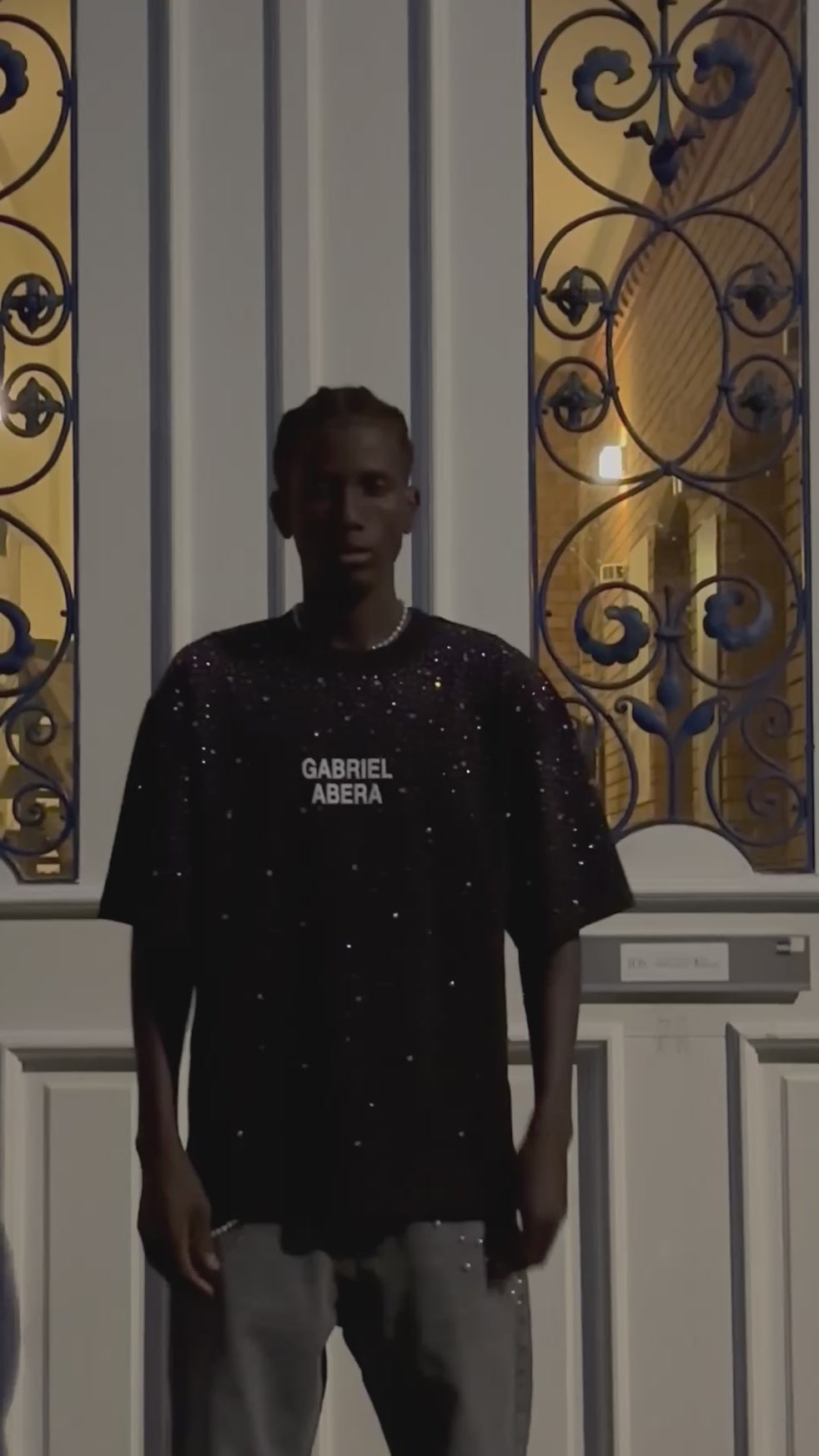 Model trägt schwarzes Rhinestone Tshirt und Jens mit Perlen von Gabriel Abera.