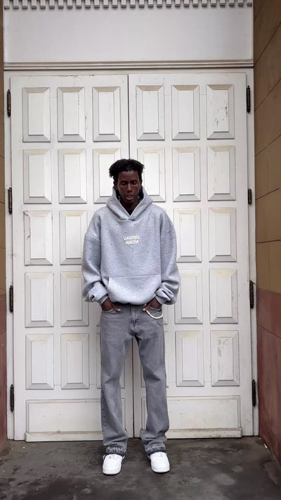 Full outfit shot of grey denim jeans with chains by GABRIEL ABERA with loose fit silhouette and rhinestone detailing on the denim.