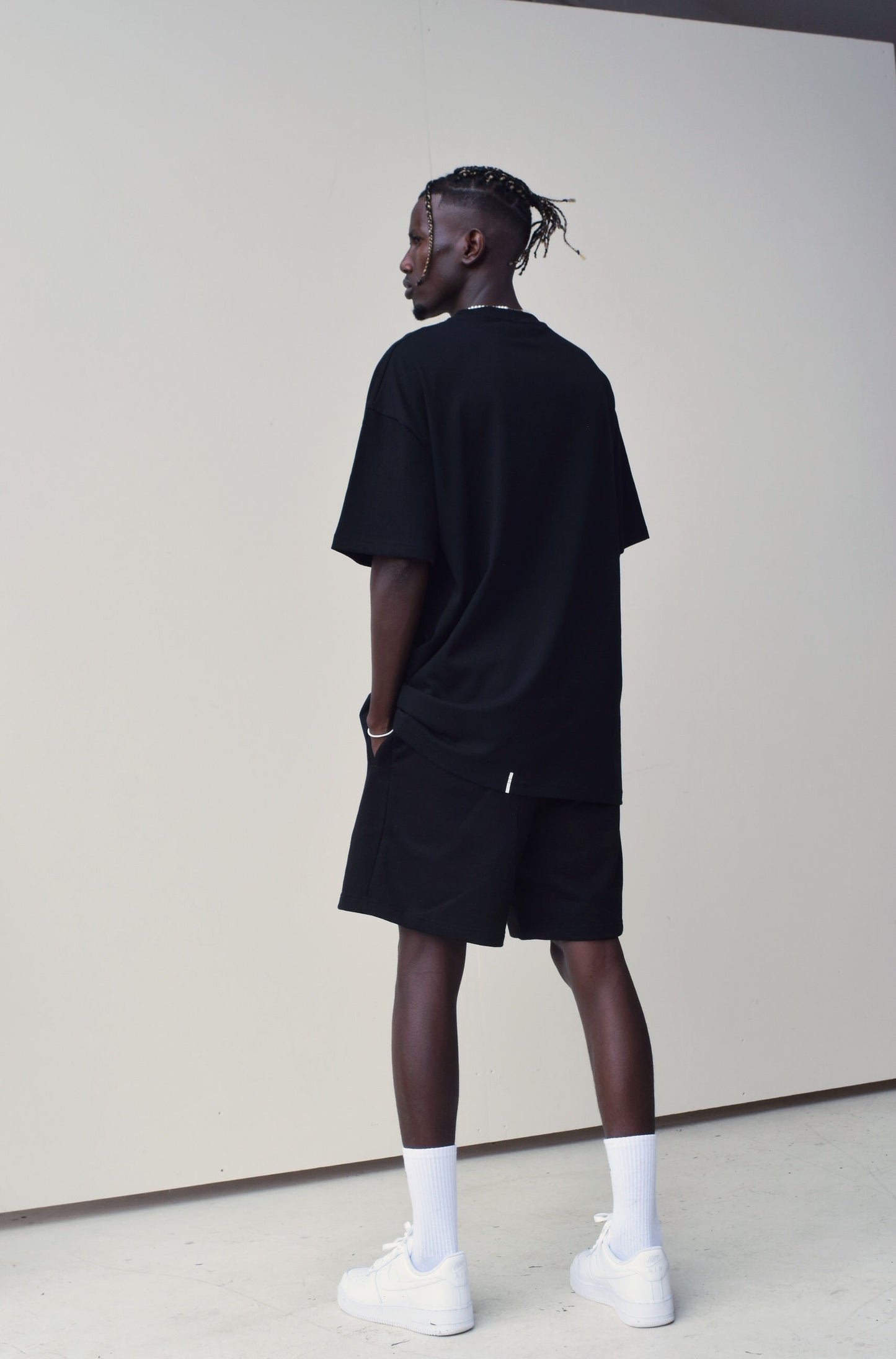 Male model wearing a Black oversize Tshirt with round brand design