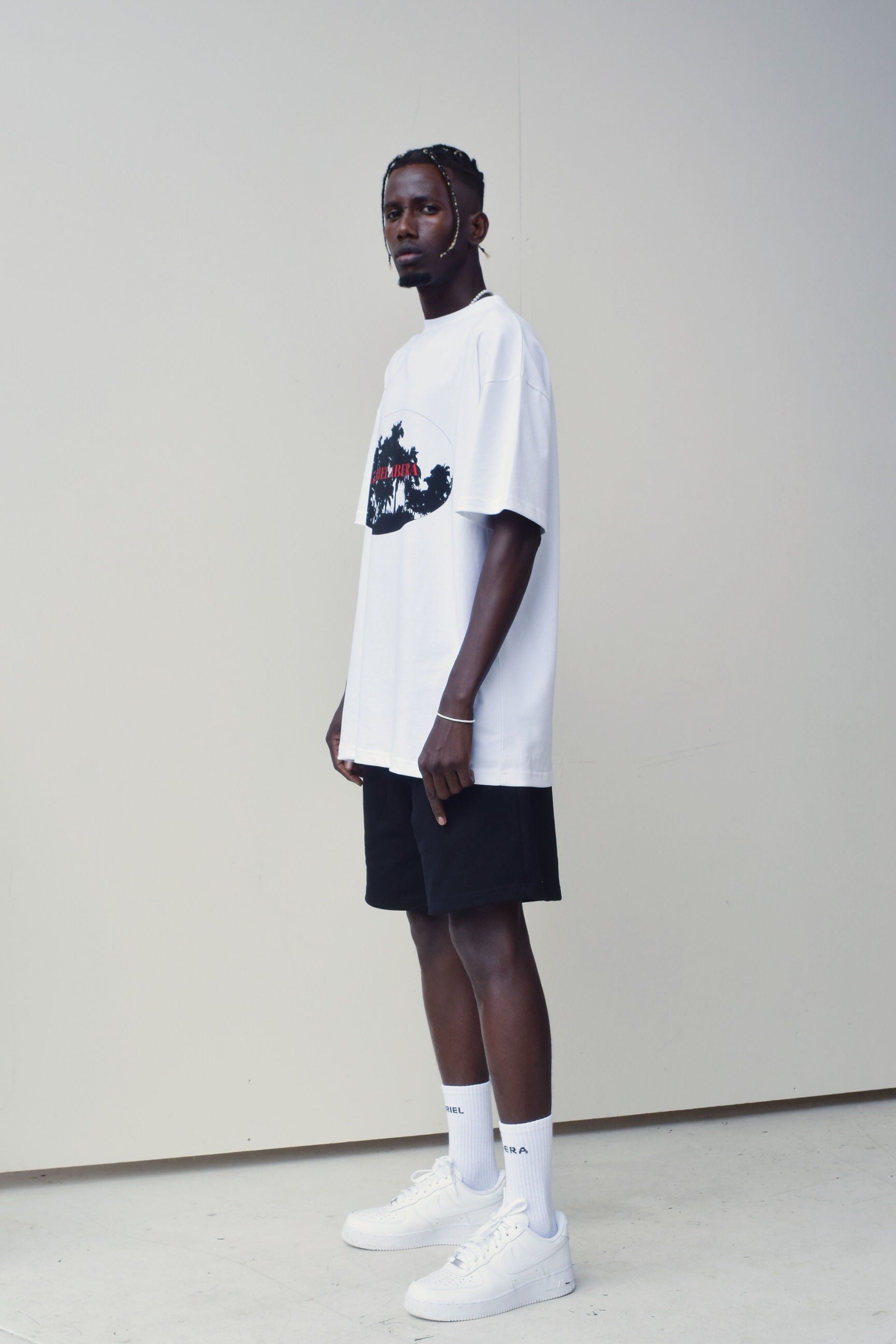 Model wearing a White oversize tshirt with black and red summer design in the front 