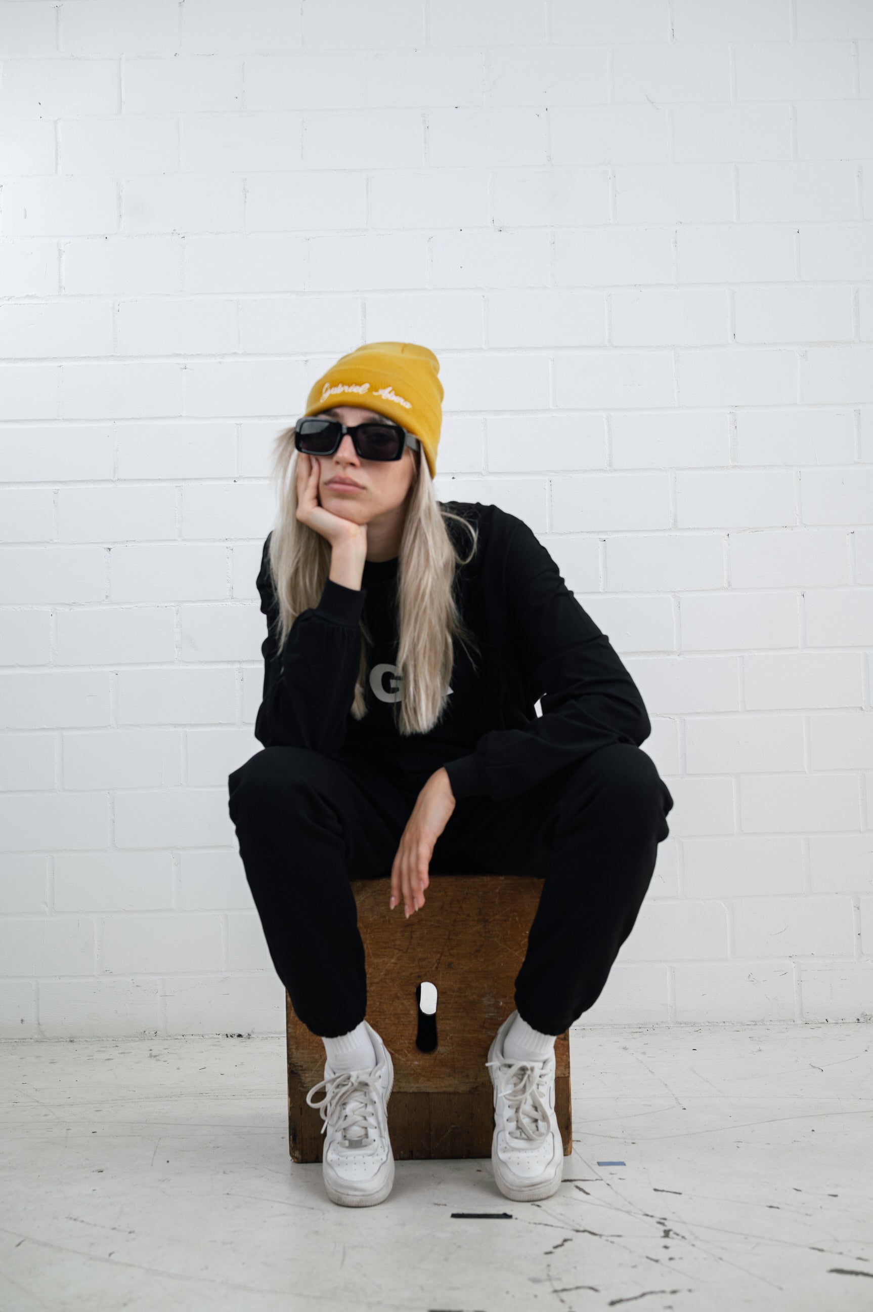 Female model wearing a Yellow beanie with brand name embroidery