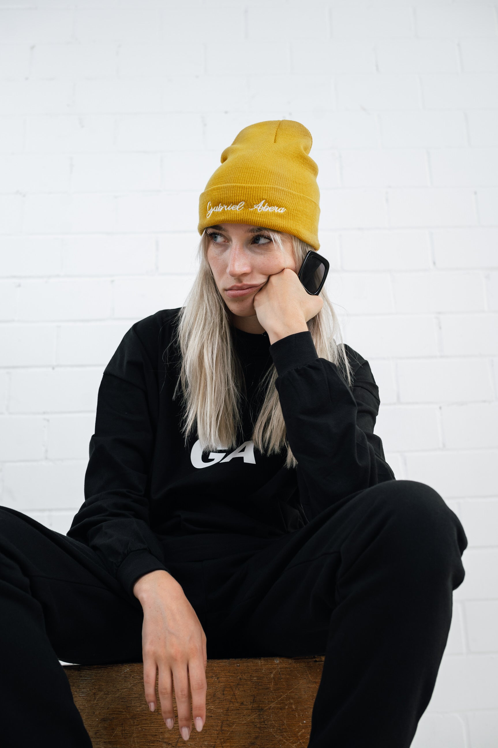 Female model wearing a Yellow beanie with brand name embroidery