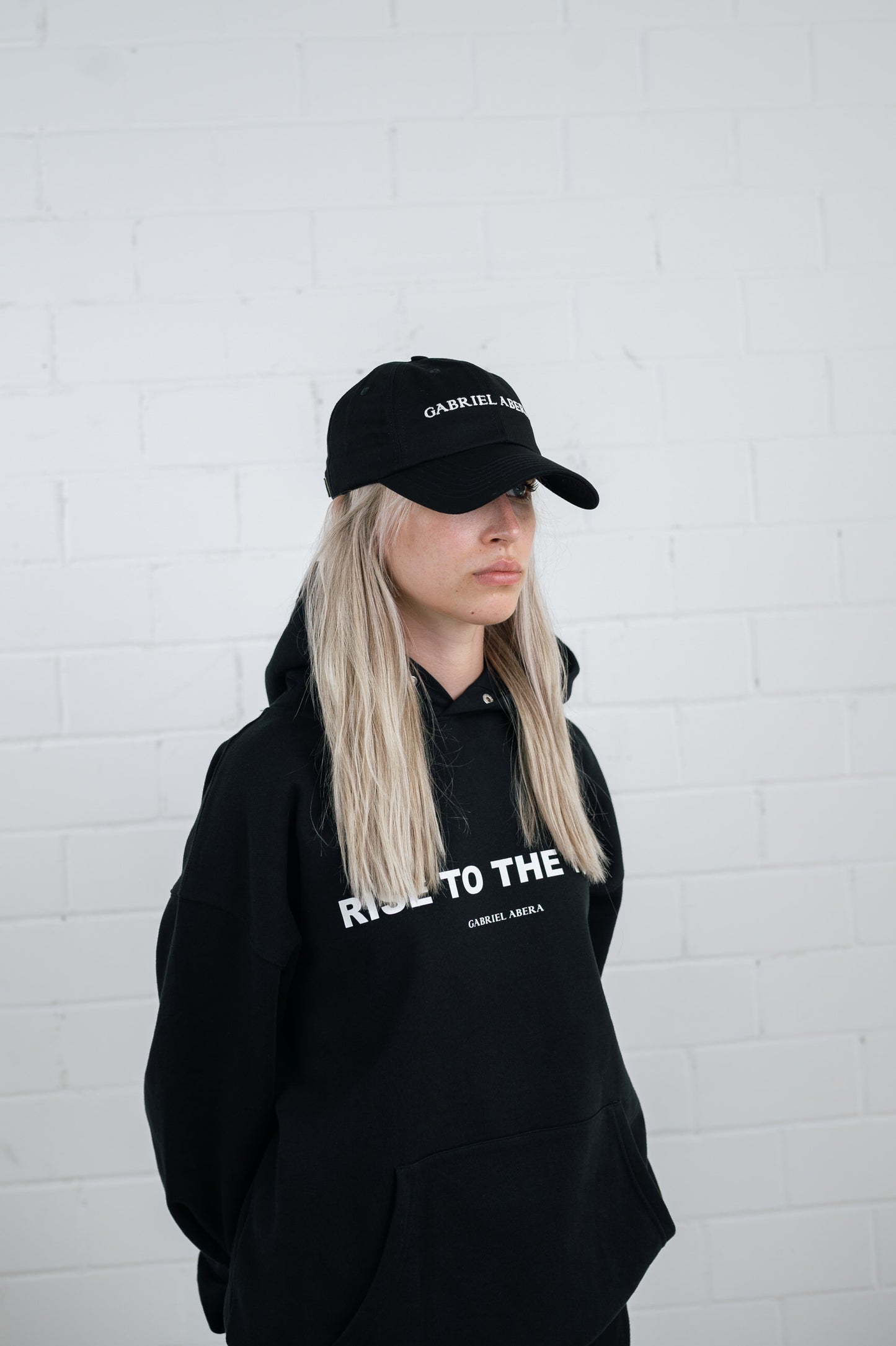 Female model wearing a Black cap with brand name embroidery