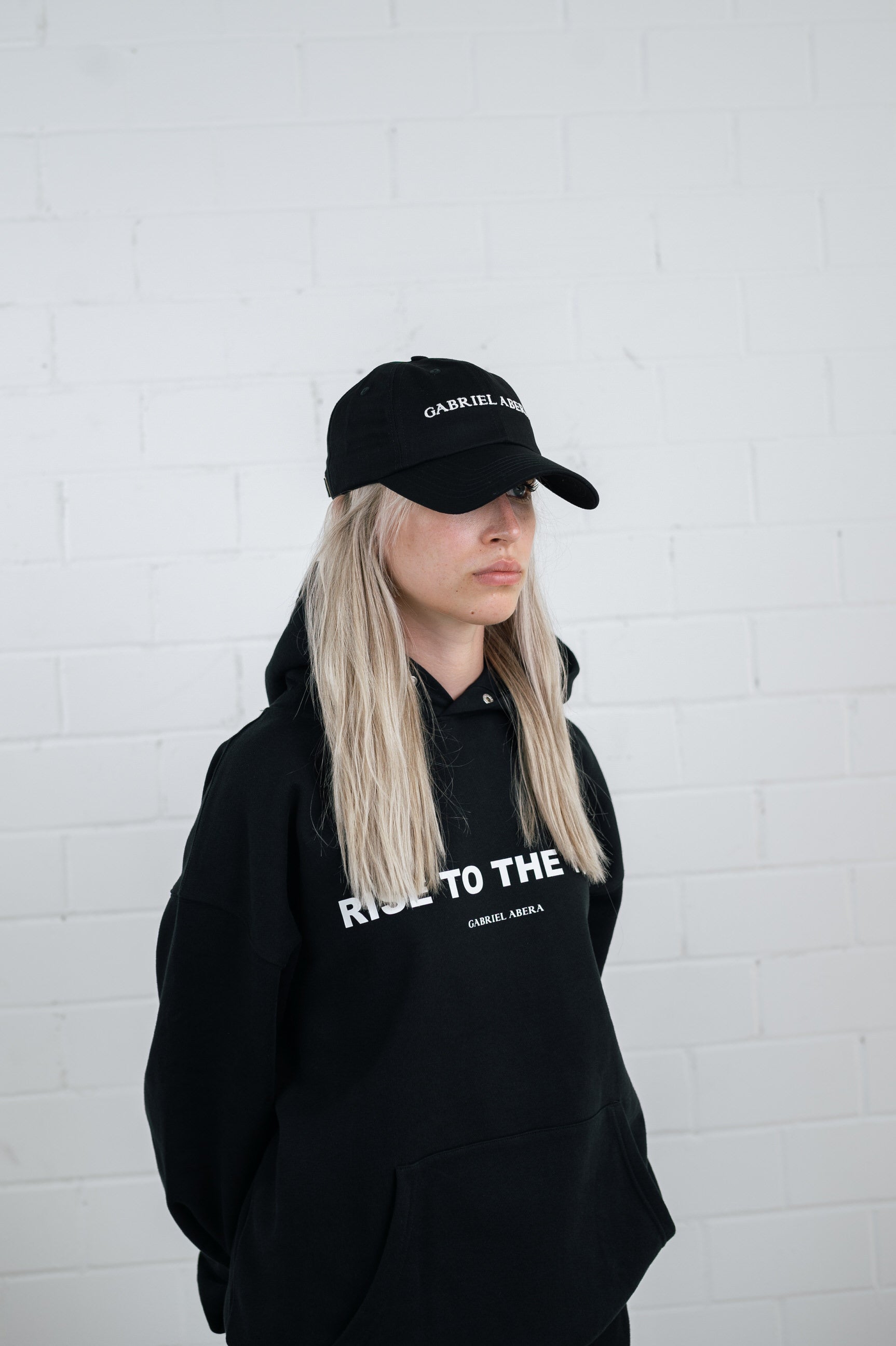 Female model wearing a Black cap with brand name embroidery