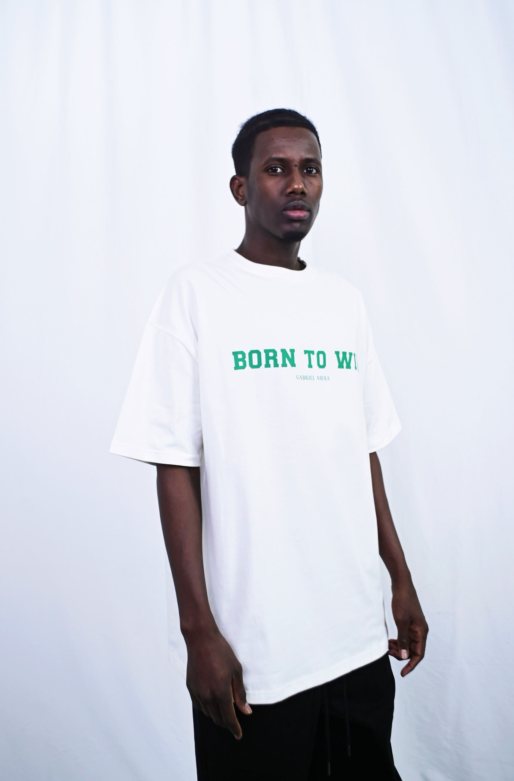 Male model wearing a White oversize tshirt with born to win design on the front