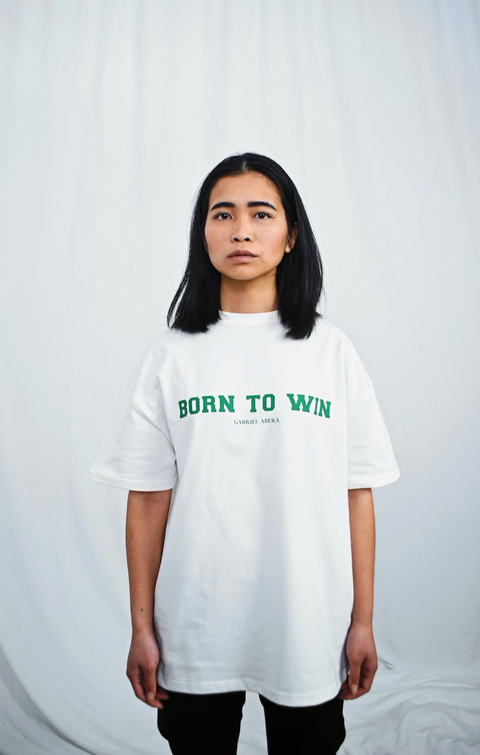 Female model wearing a White oversize tshirt with born to win design on the front