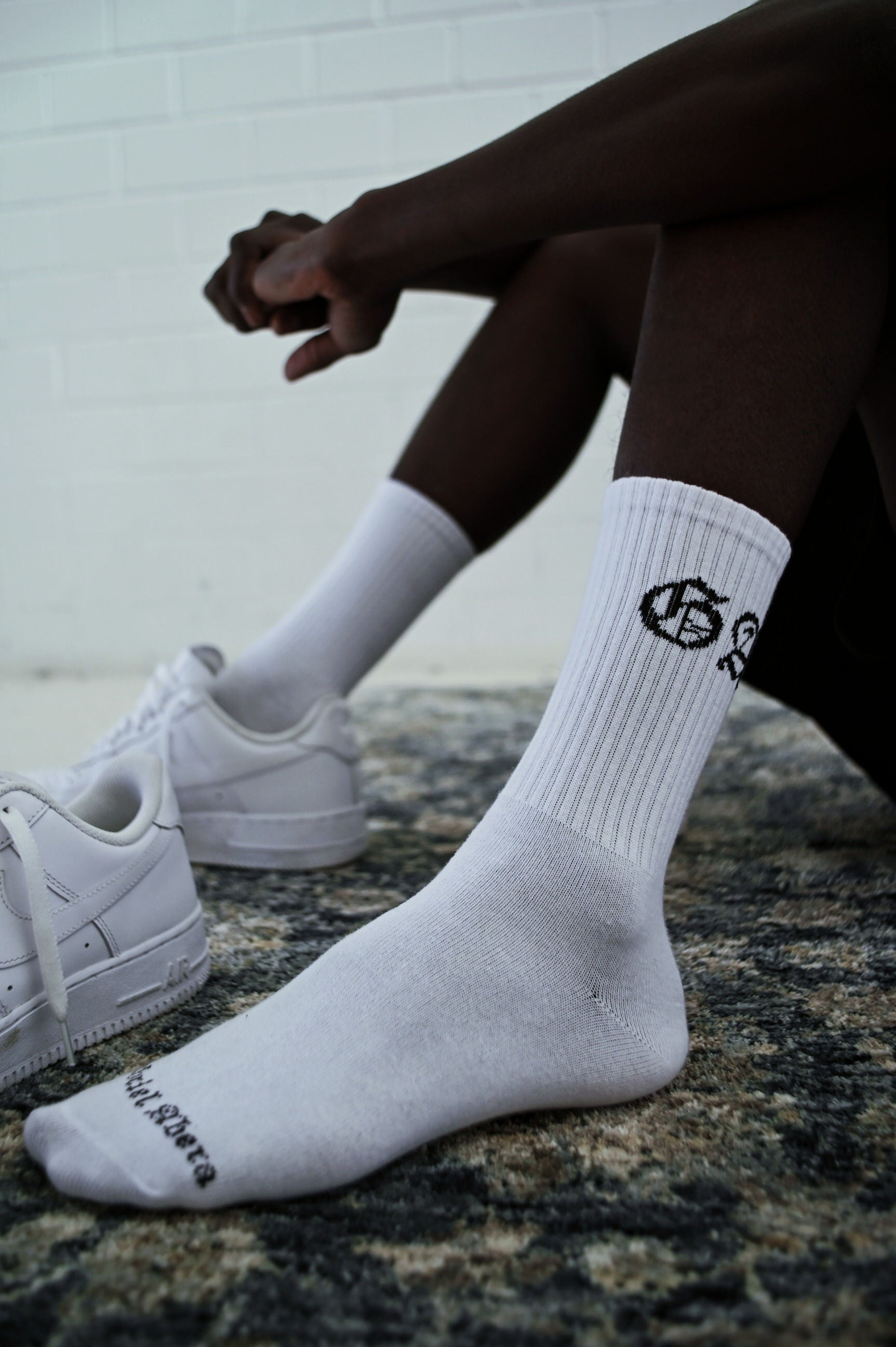 Model wearing a pair of socks with capital letters GA in black and white