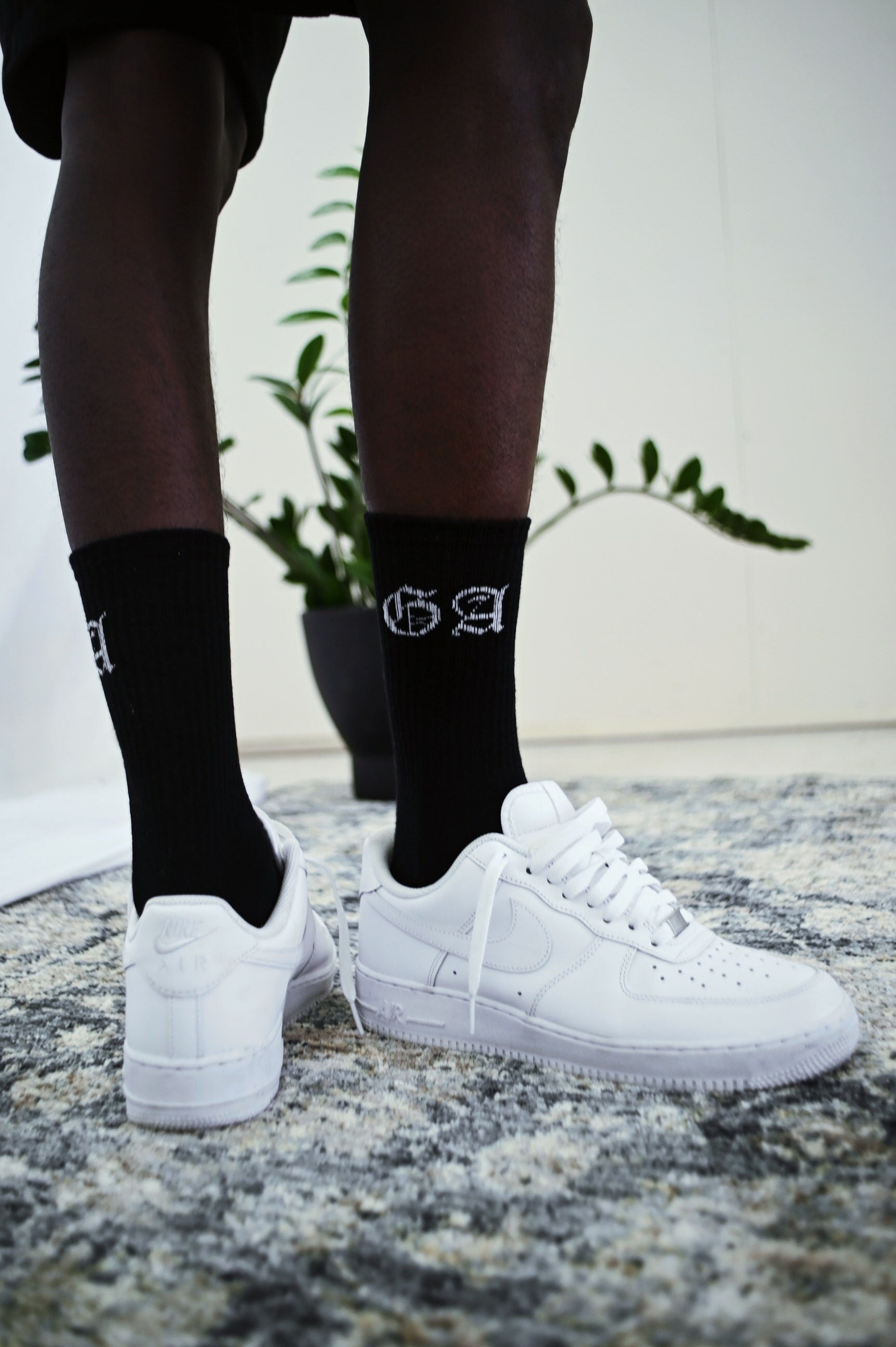 Model wearing a pairs of socks with capital letters GA in black and white